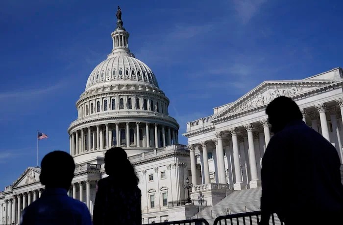 FILE - People walk outside the U.S. Capitol building in Washington on June 9, 2022.